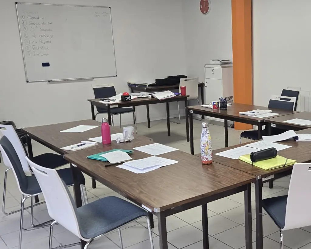 La salle de réunion de L'Atelier KS à La Rochelle pendant une formation : des feuilles et des gourdes sur les tables, et au mur un tableau blanc où est écrit un plan en sept points, de la préparation à la conclusion.