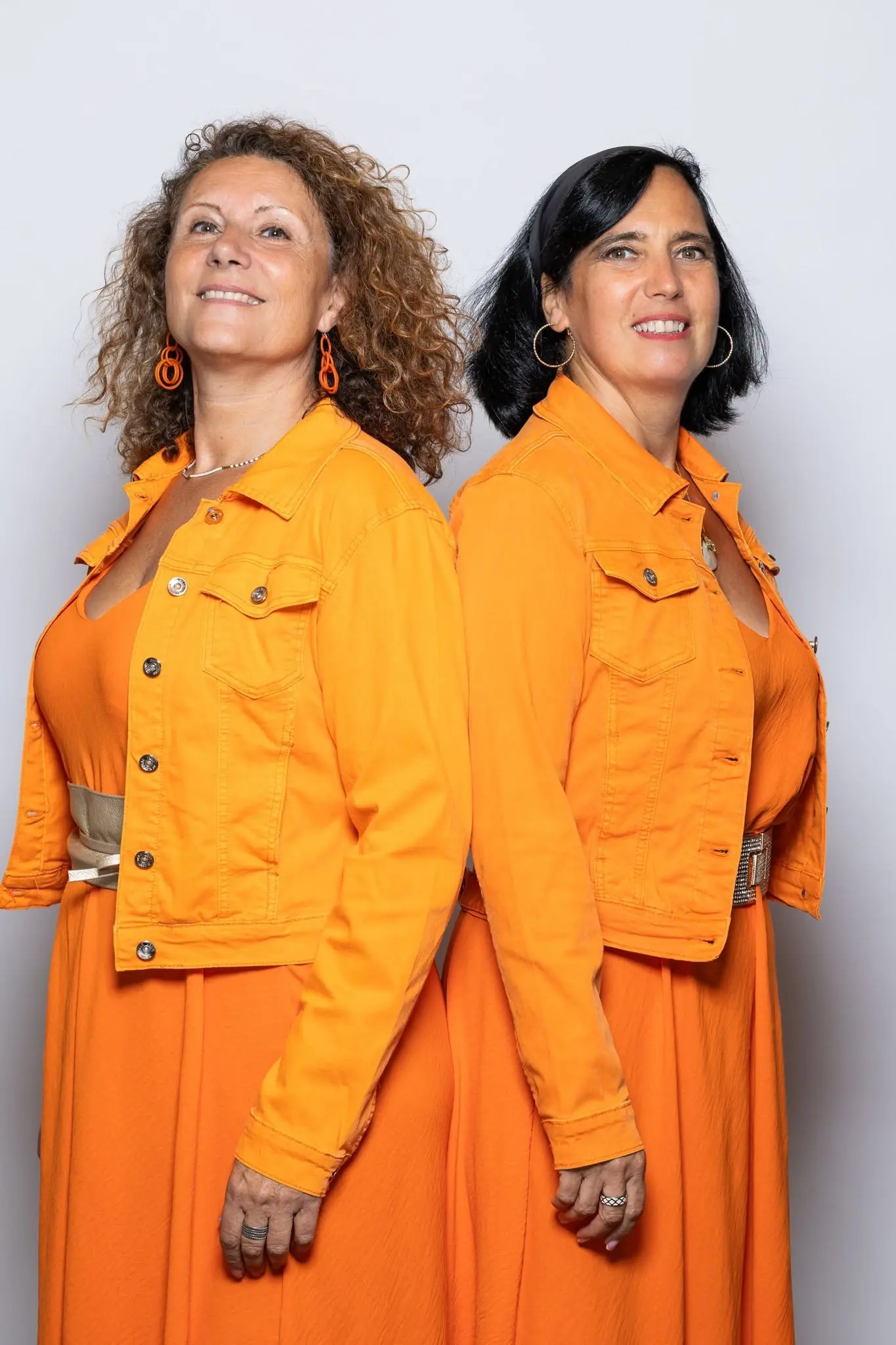 Karine Monbillard et Sendrine Colly, fondatrices de l'Atelier KS, dos à dos en tenue orange